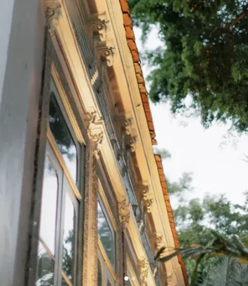 Detalhe dos ornamentos da cornija e das janelas do casarão, sob o beiral de telhas